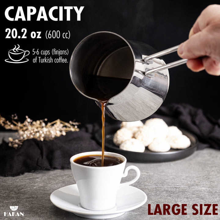 A person pours Turkish coffee from a midi-size 20.2 oz (600 cc) stainless steel pot into a white cup, suitable for 5-6 cups of Turkish coffee.